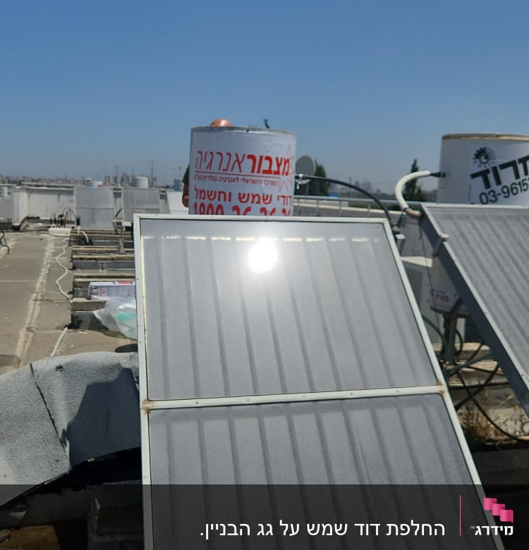 דוד שמש עם קולטים על גג תחת שמיים כחולים